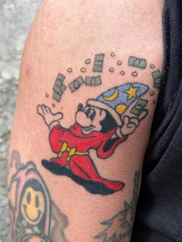 Mickey apprenti sorcier faisant pleuvoir des billets, en couleur, sur un bras